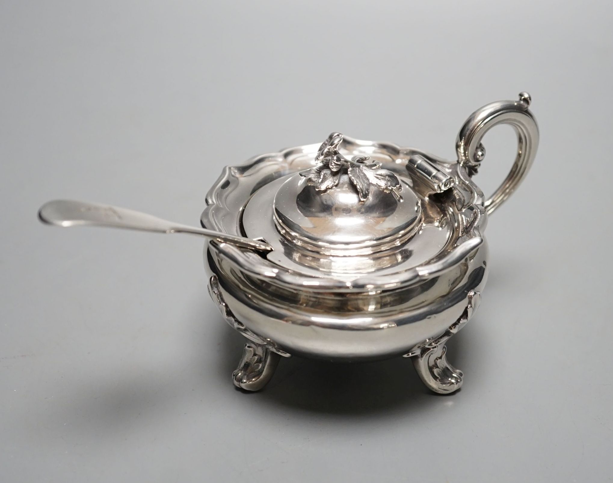 A late William IV silver circular mustard pot, with blue glass liner, The Barnards, London, 1837, with earlier associated fiddle pattern mustard spoon.